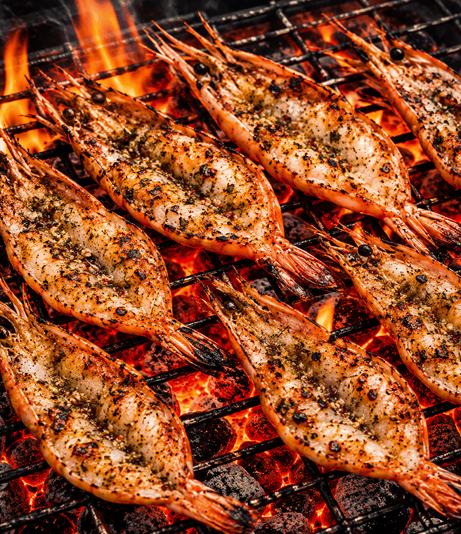Prawns cooking over hot coals